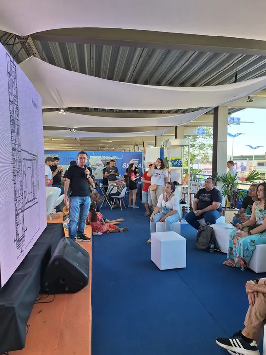 Pessoas acompanham uma conversa em um espaço aberto de inovação