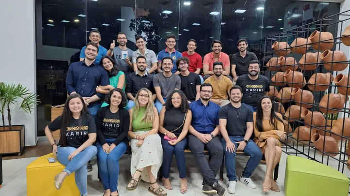 Grupo da comunidade reunido em um espaço de encontro, com pessoas sentadas e em pé