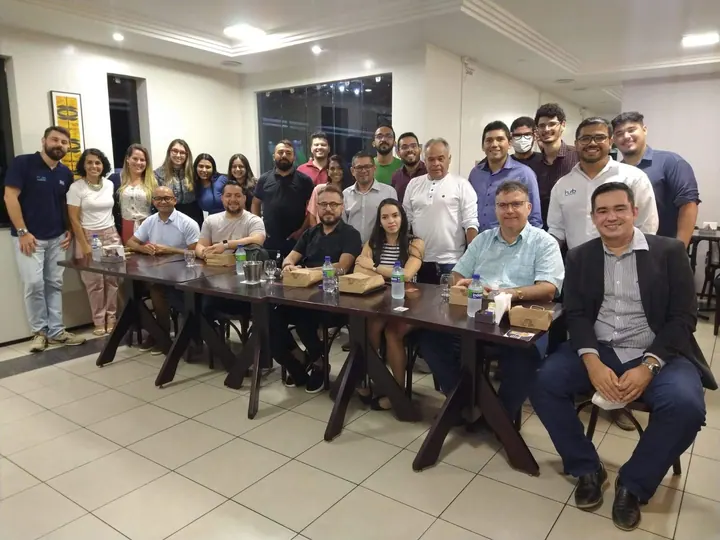 Grupo da comunidade reunido em torno de mesas após uma conversa