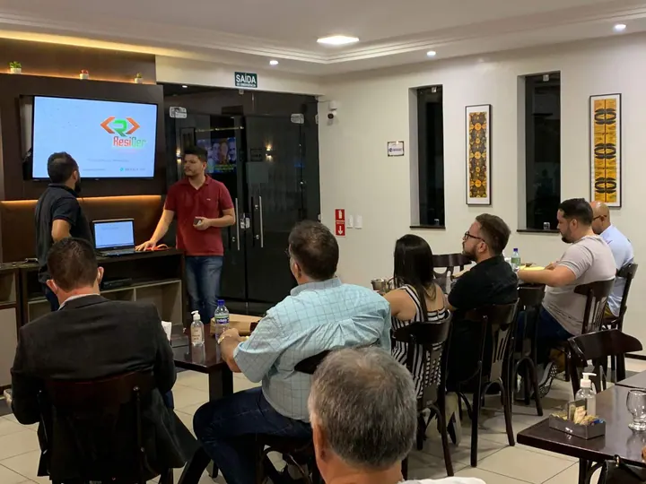 Participante apresenta ideias a um grupo sentado em uma sala