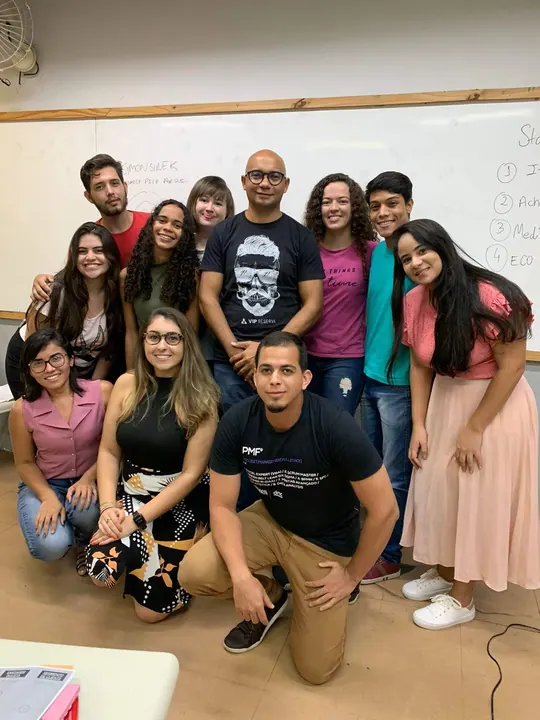 Pessoas da comunidade reunidas para uma fotografia de grupo em uma sala