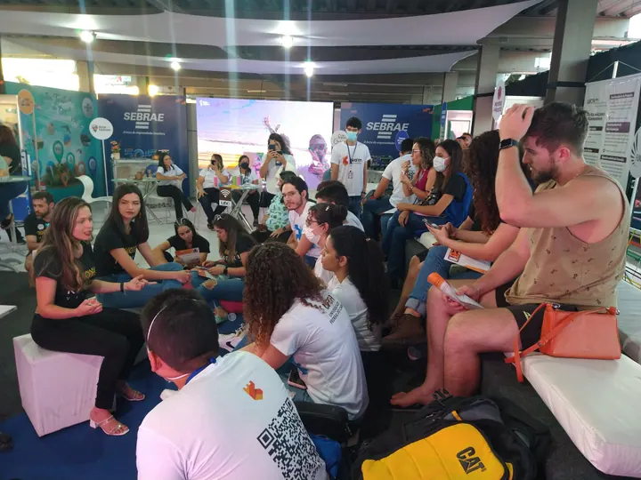 Participante fala a uma roda de pessoas em um espaço de inovação
