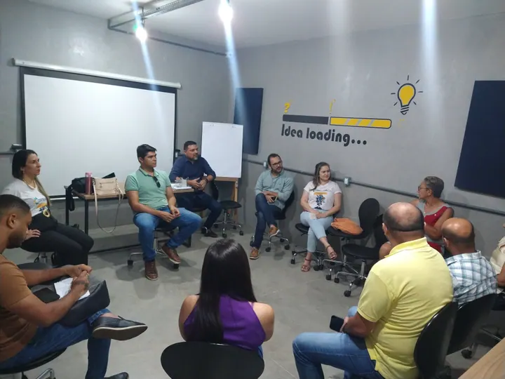Pessoas reunidas em círculo conversam em uma sala de inovação