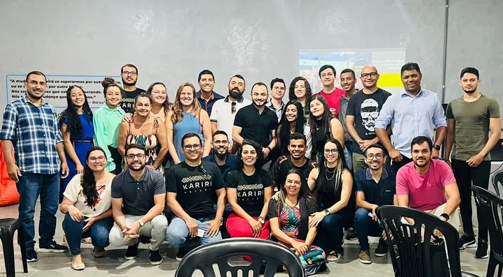 Grupo da comunidade reunido após uma apresentação em uma sala