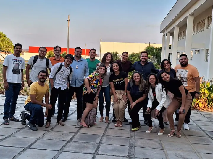 Pessoas da comunidade reunidas ao ar livre, em frente a um edifício