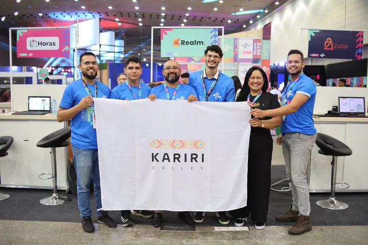 Participantes seguram a bandeira do Kariri Valley em um espaço de exposição