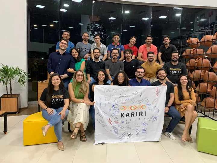 Grupo da comunidade reunido com a bandeira do Kariri Valley em um espaço de encontro